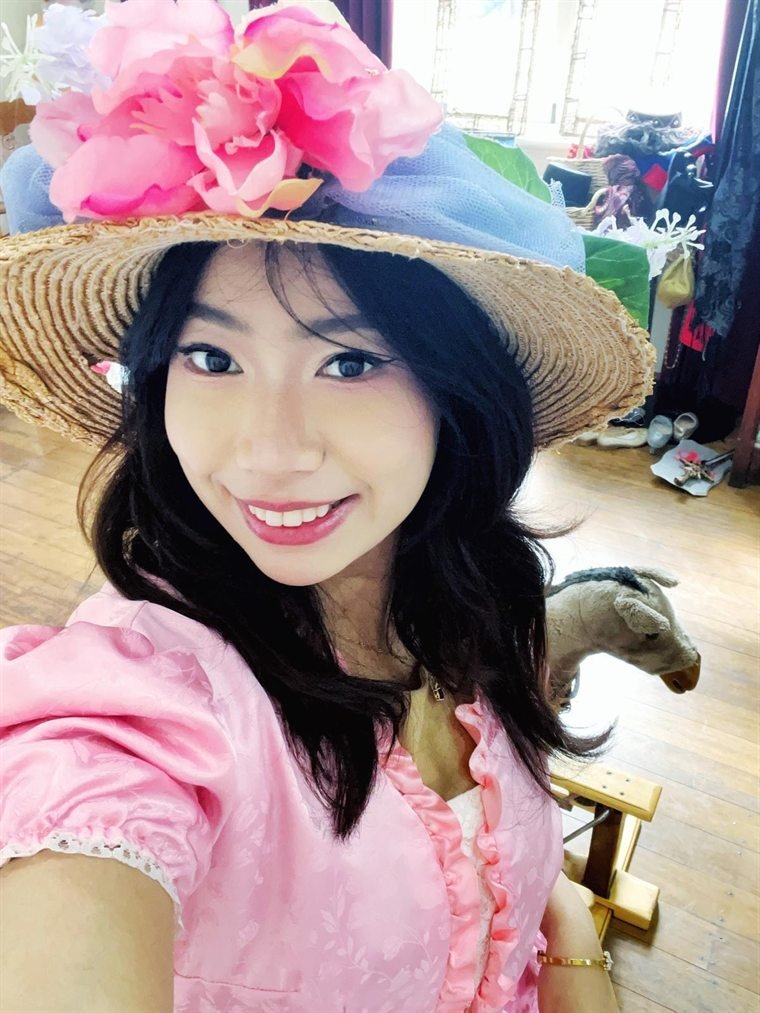 Thiri, the owner of Fotobooth Perth, in a flower-trimmed straw hat and pink dress
