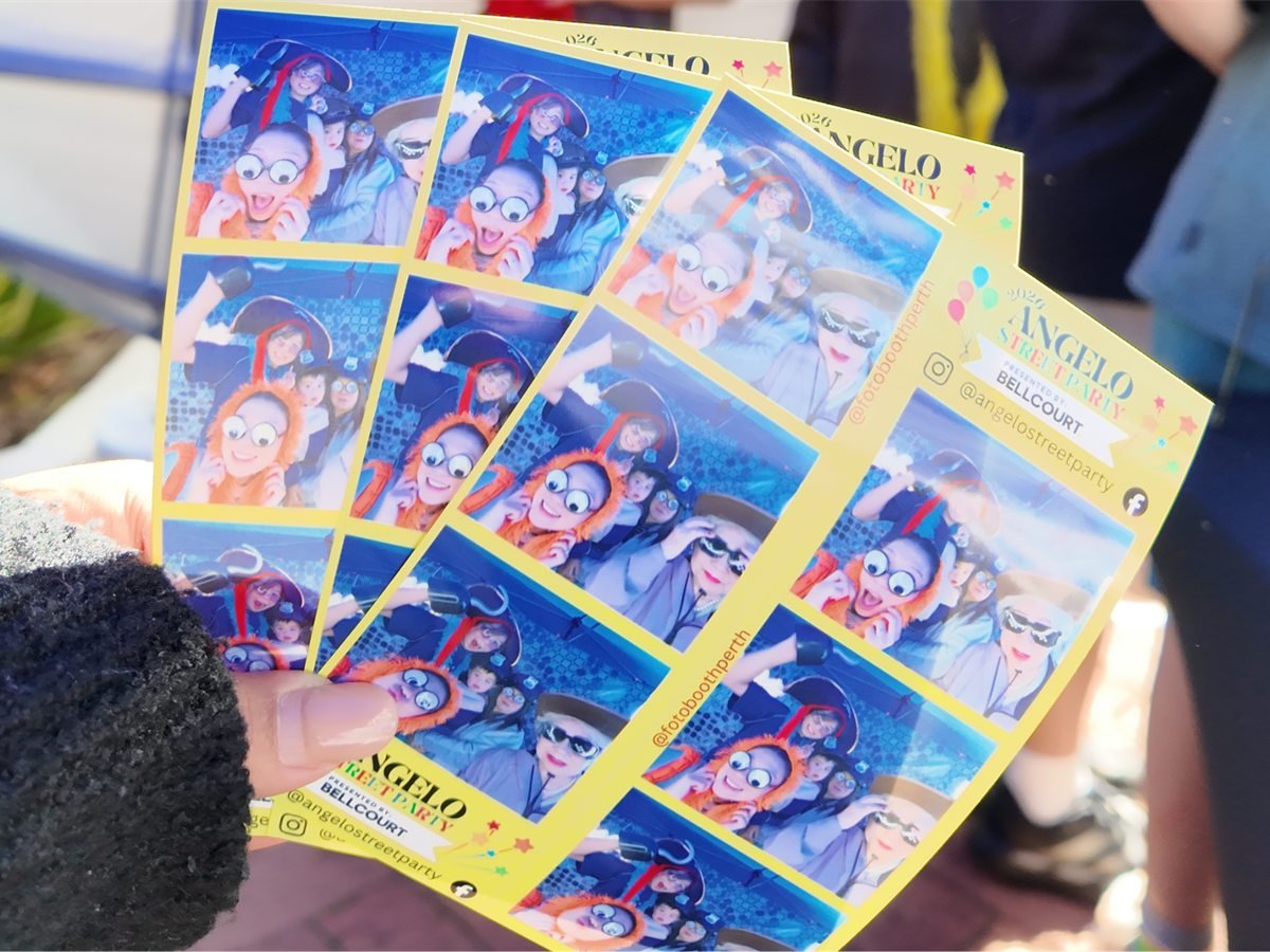 Freshly printed photo strips from the Angelo Street Party in the branded yellow event template, handed to guests at the booth