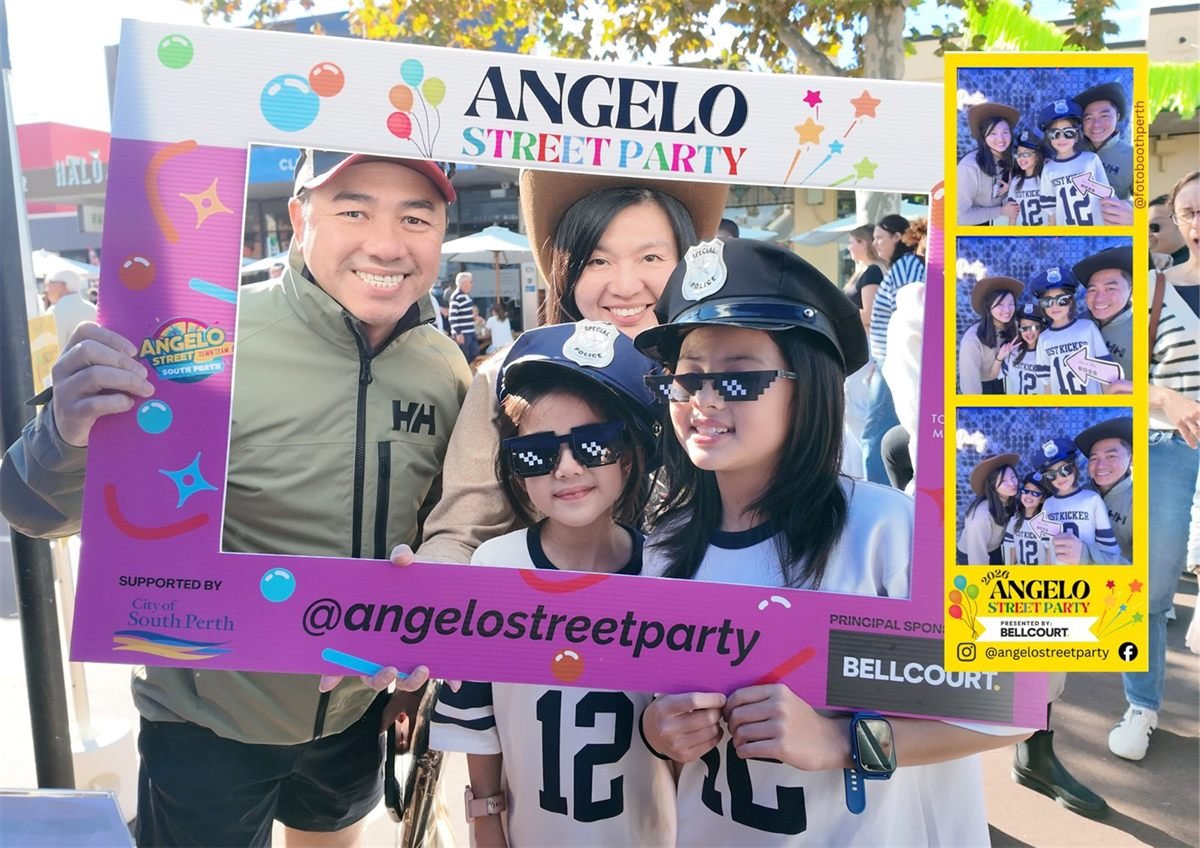 Guests posing behind the branded Angelo Street Party selfie frame at the 2026 event in South Perth, with their printed photo strip shown alongside