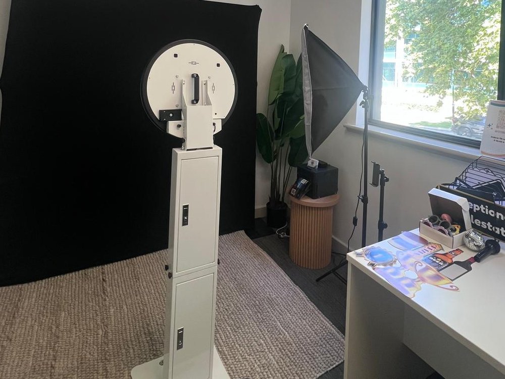 A Fotobooth Perth booth set up and ready in a Perth office before a corporate event, with a black backdrop, studio lighting and a prop table